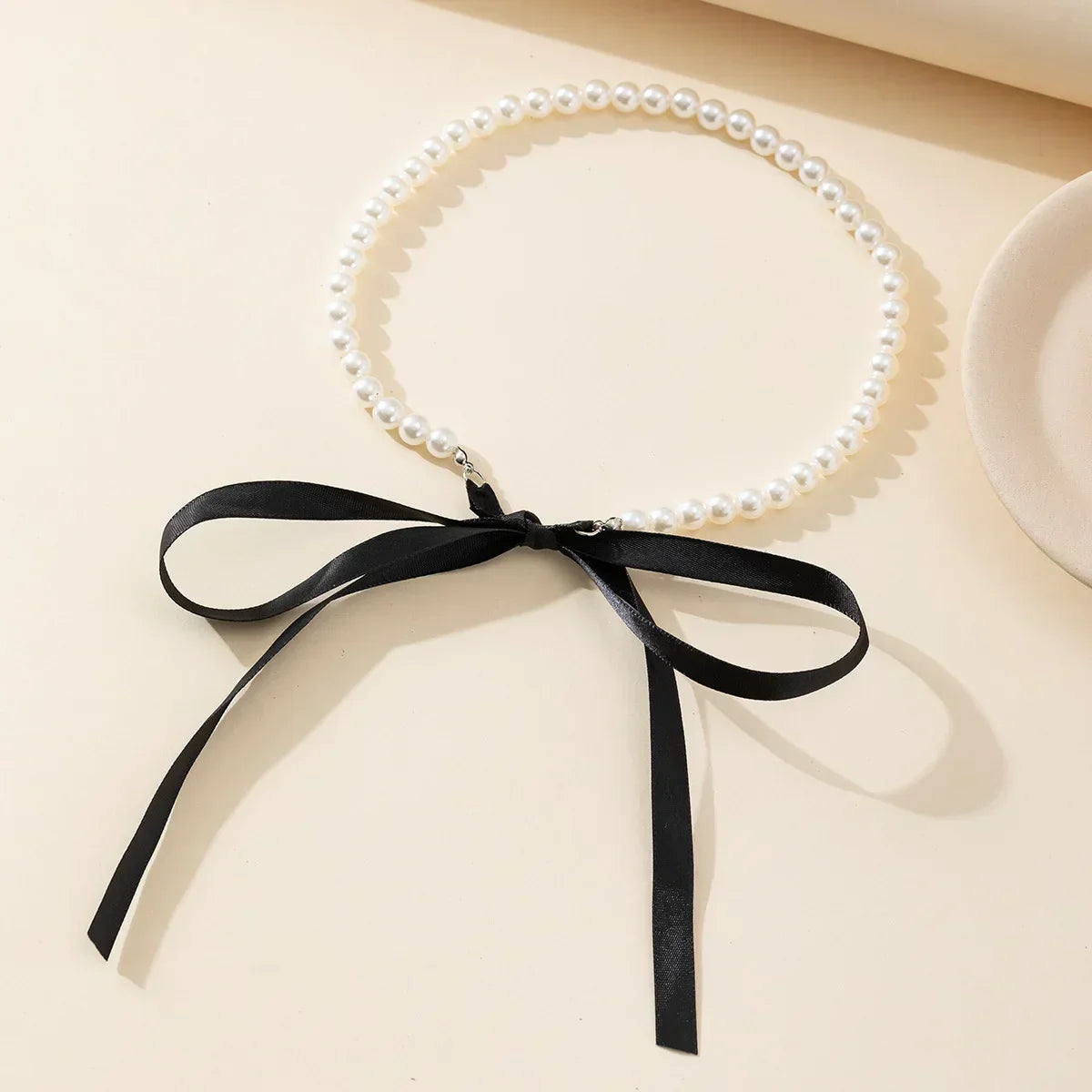 Collier ras du cou avec un nœud et des perles
